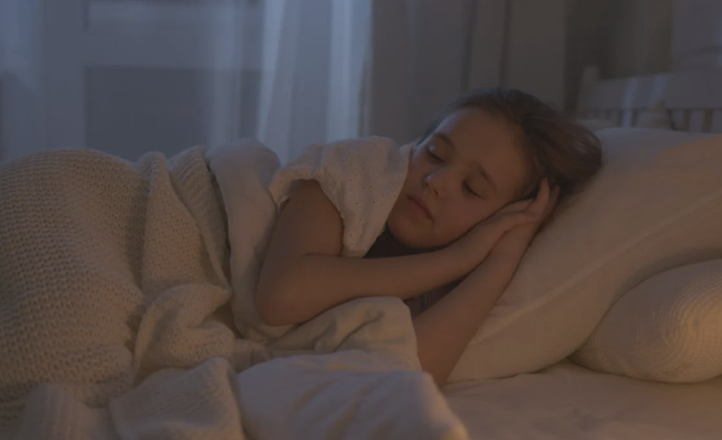a little girl sleeping on the bed